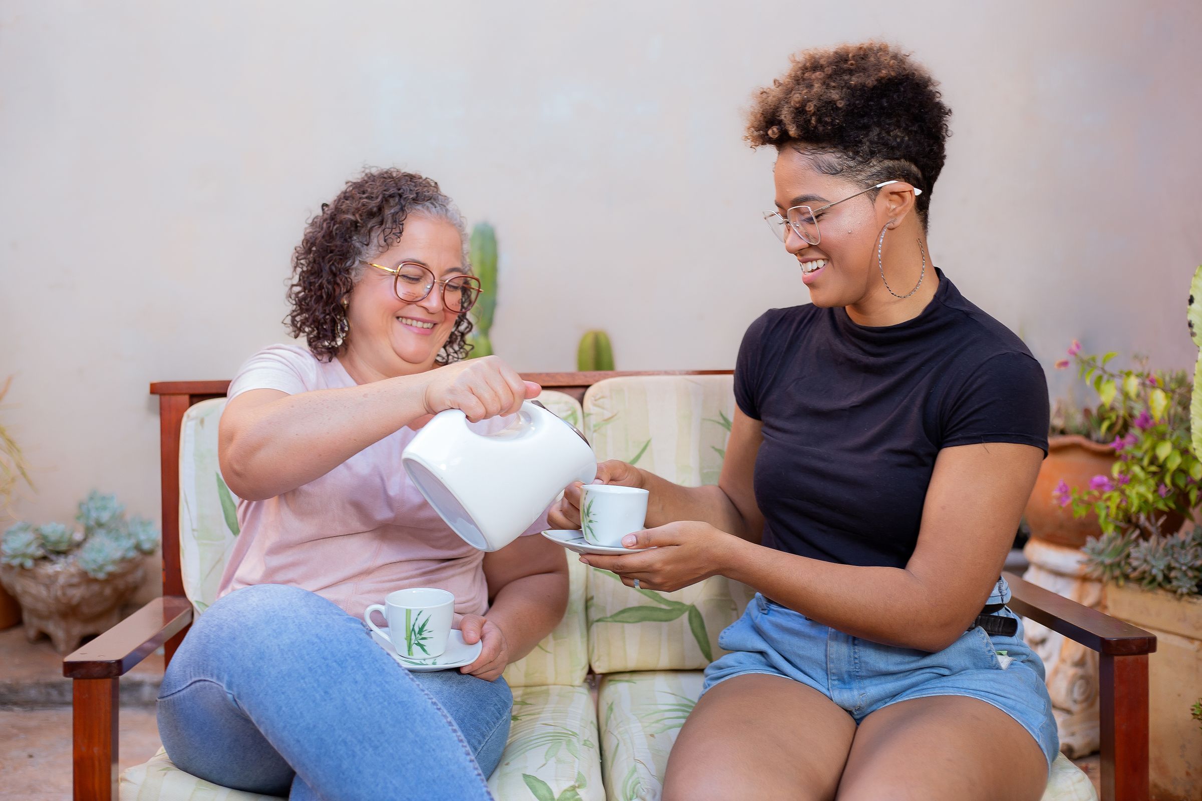 An adult daughter sharing tea with her older mother at home