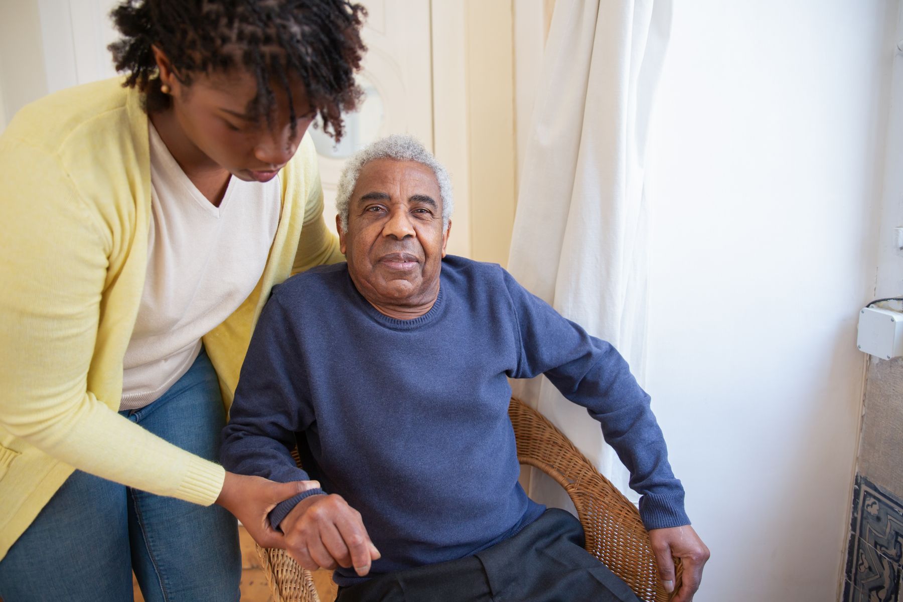An adult daughter helping her older father at home